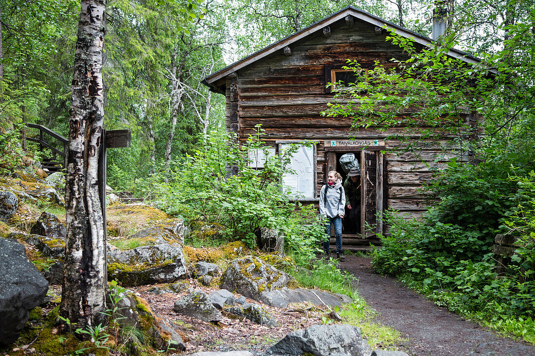 Hiker in front of hut Taivalkoengas, Karhunkierros hiking trail, Oulanka National Park, Northern Ostrobothnia, Finland