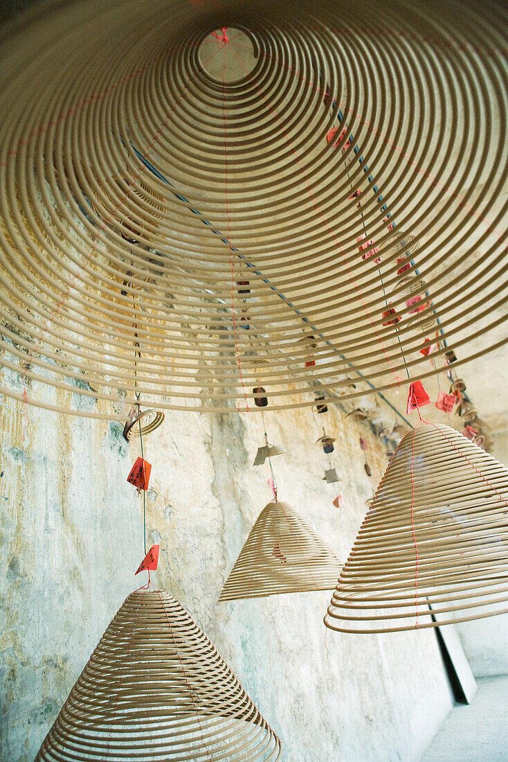 Spirals of incense hanging from ceiling