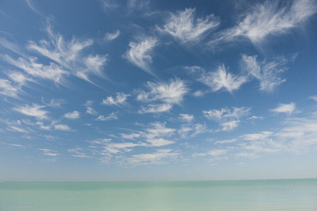 Wispy clouds over tranquil sea