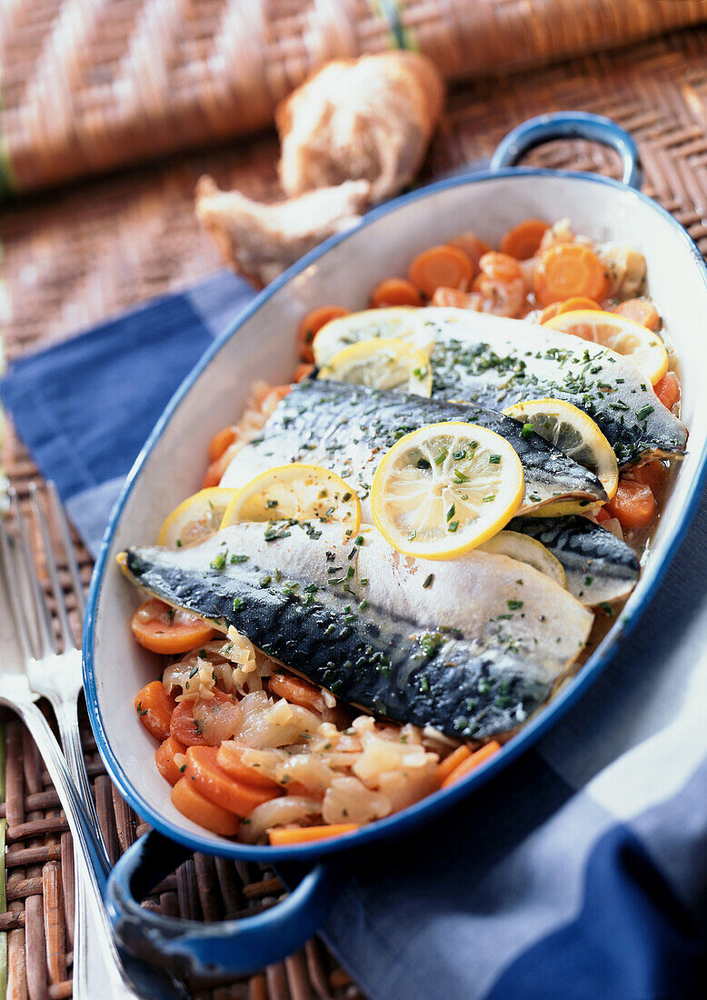 Mackerel in casserole dish with vegetables, close-up