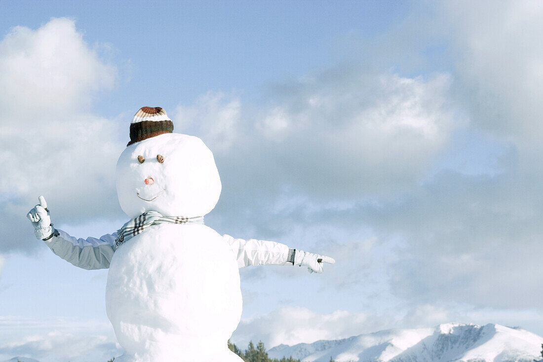 Snowman, person's arms emerging from behind, pointing in different directions