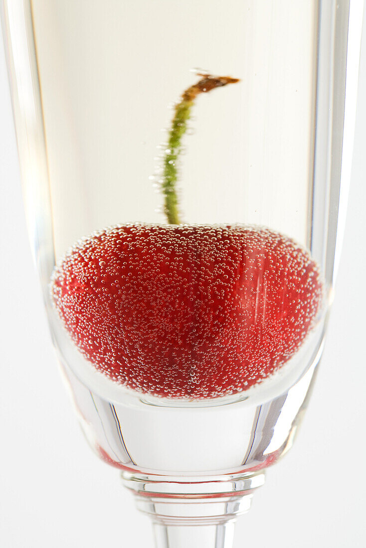 Cherry in glass of champagne, close-up