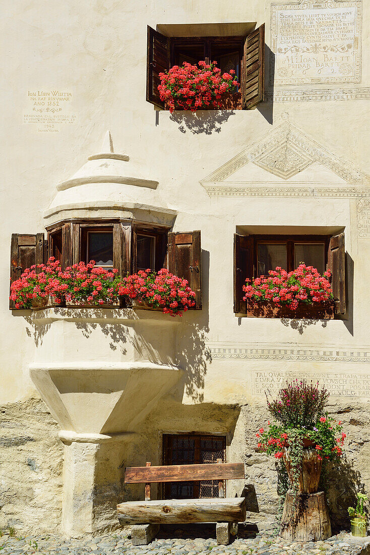 Mit Blumen geschmückter Erker und Fenster von einem Engadinerhaus, Guarda, Unterengadin, Engadin, Kanton Graubünden, Schweiz