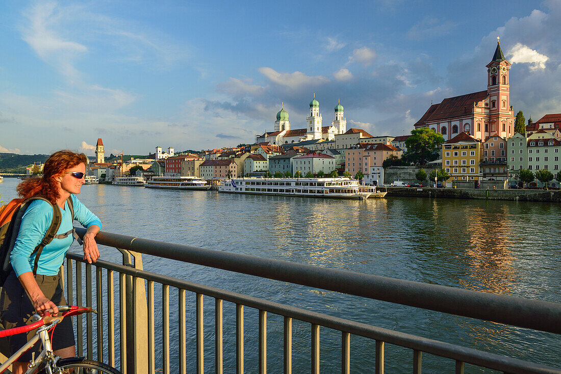 Cyclist looking over Danube river to Passau, Lower Bavaria, Germany