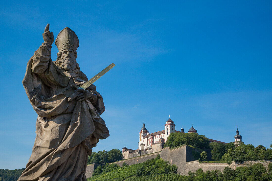 Statue auf Alte Mainbrücke über Fluss Main mit Festung Marienberg im Hintergrund, Würzburg, Franken, Bayern, Deutschland