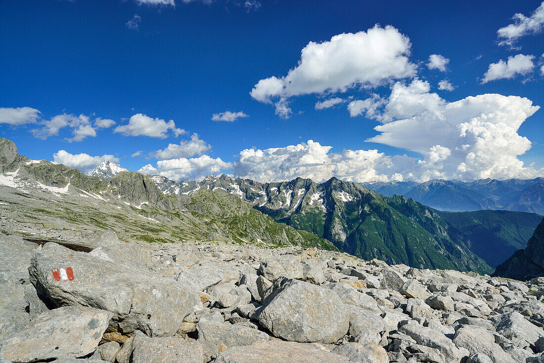 Rocks in cirque with marker with Monte Disgrazia in background, Sentiero Roma, Bergell range, Lombardy, Italy