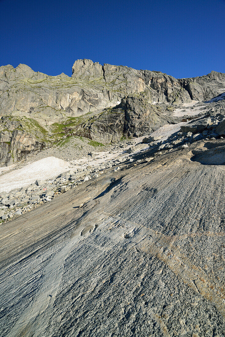 Rock slab polished by glacier with granite mountains in background, Sentiero Roma, Bergell range, Lombardy, Italy