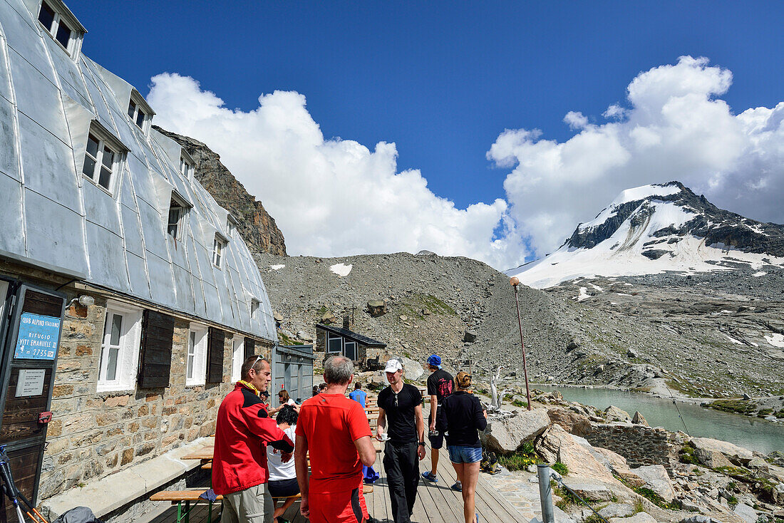 Mehrere Personen stehen am Rifugio Vittorio Emanuele II, La Tresenta im Hintergrund, Gran Paradiso, Nationalpark Gran Paradiso, Grajische Alpen, Aostatal, Aosta, Italien
