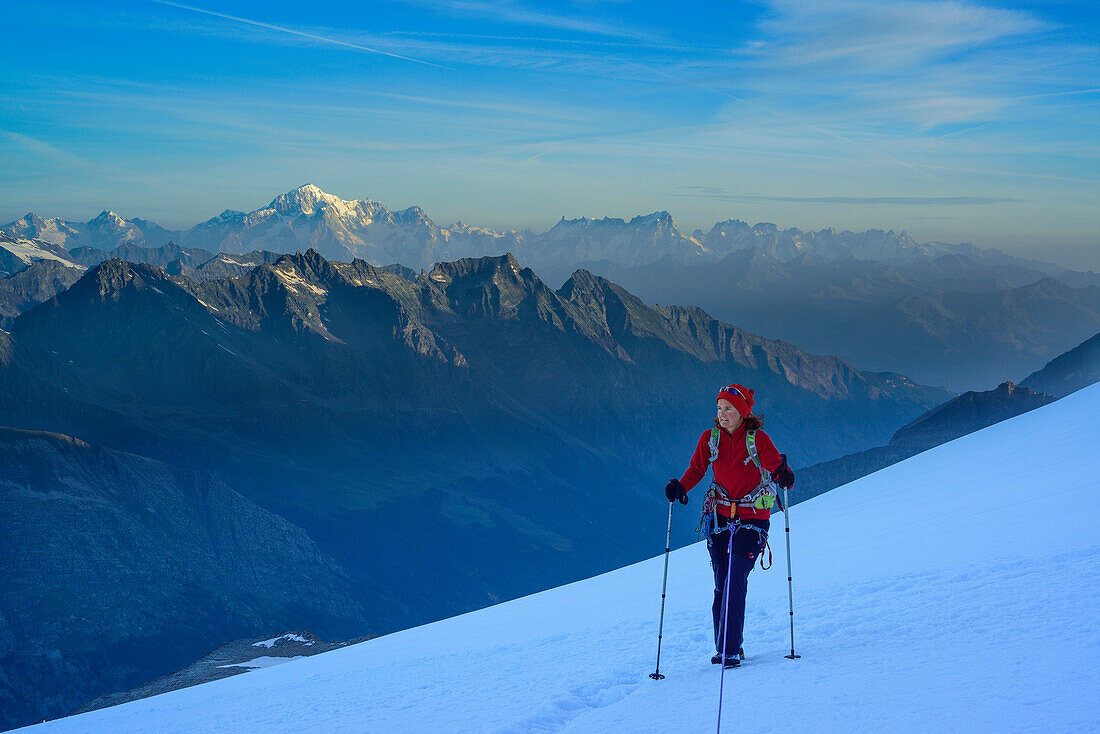 Frau steigt angeseilt über Gletscher zum Gran Paradiso auf, Mont Blanc im Hintergrund, Gran Paradiso, Nationalpark Gran Paradiso, Grajische Alpen, Aostatal, Aosta, Italien