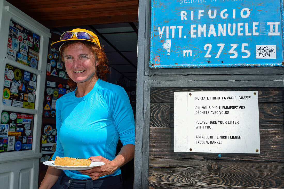 Frau steht mit Kuchen am Rifugio Vittorio Emanuele II, Gran Paradiso, Nationalpark Gran Paradiso, Grajische Alpen, Aostatal, Aosta, Italien