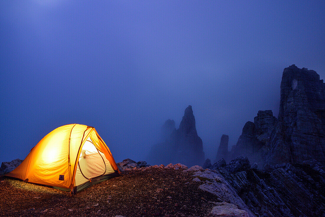 Illuminated tent standing in front of Torre di Pisa, Torre di Pisa, Latemar range, Dolomites, UNESCO world heritage Dolomites, Trentino, Italy