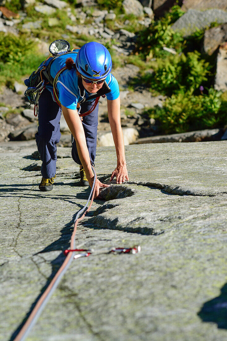 Frau klettert an Granitplatten, Azalee Beach, Grimselpass, Berner Oberland, Schweiz