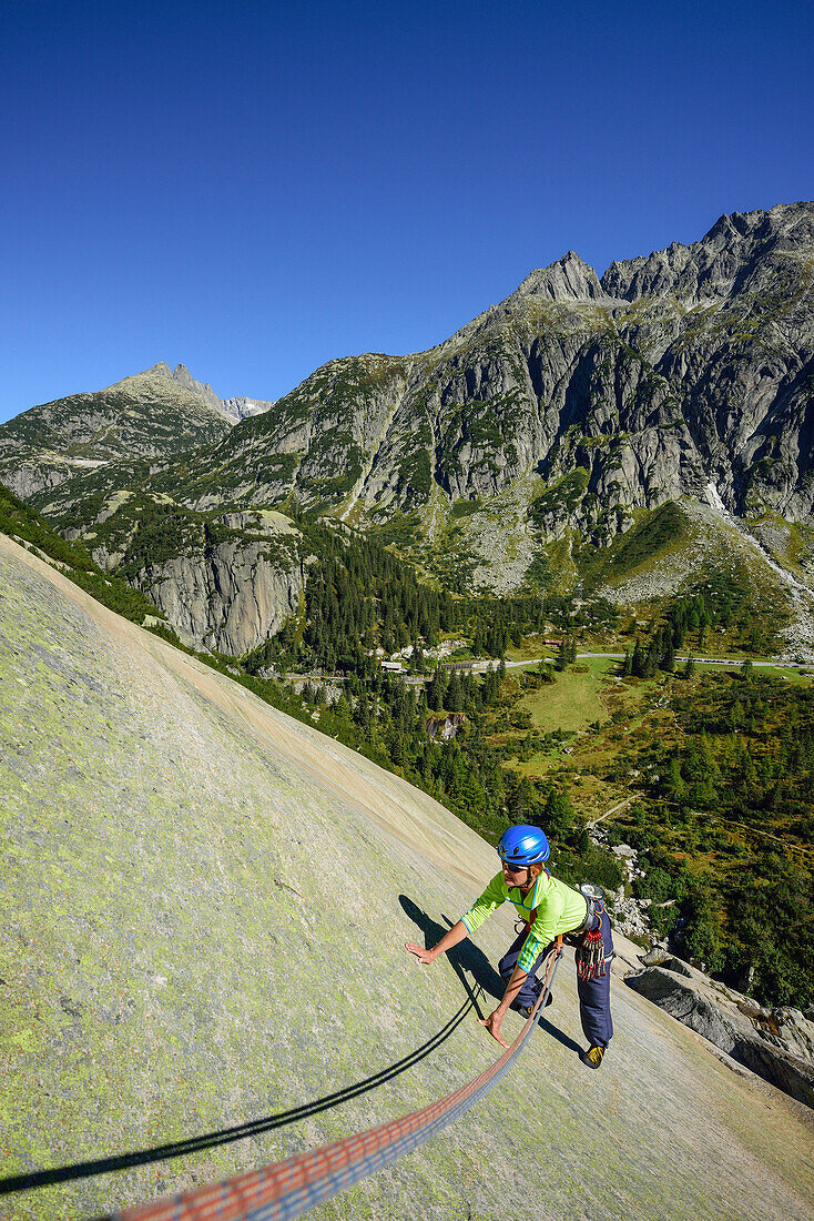 Woman climbing on granite slab, Sector Crow, Grimsel pass, Bernese Oberland, Switzerland