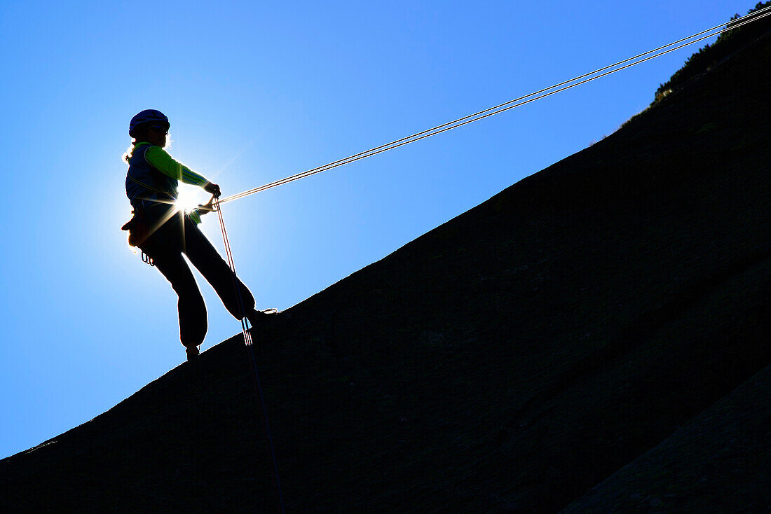 Woman climbing rappelling down, Sector Crow, Grimsel pass, Bernese Oberland, Switzerland