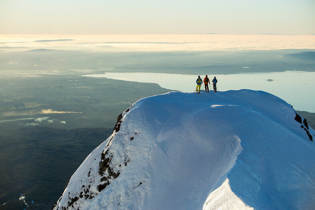 Three people standing on the top of the mountain, Skitour on vulcano Villarica, Pucon, Chile