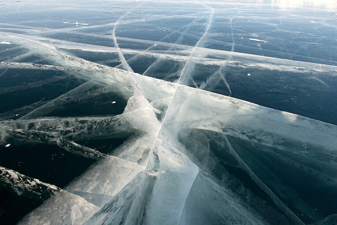 Pressure cracks appear in the 80cm thick clear black ice on the surface of the 800m deep frozen Lake Baikal, Irkutsk Oblast, Siberia, Russia, Eurasia
