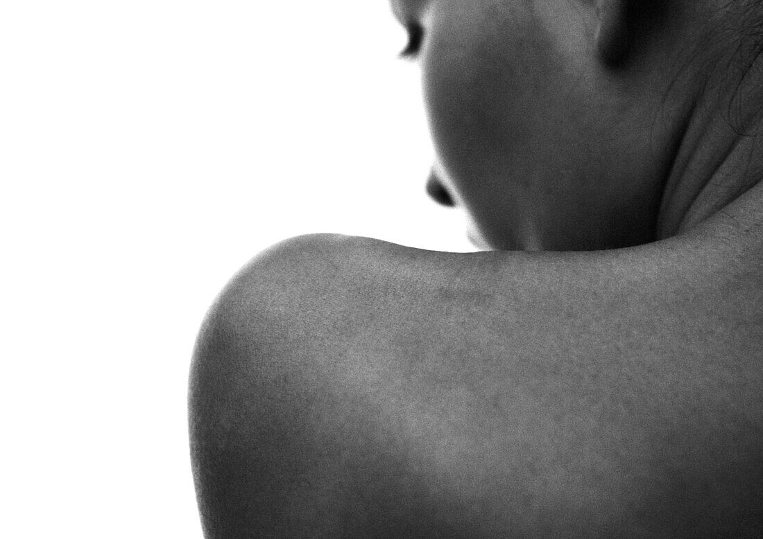 Woman's face and bare shoulder, partial view, rear view, close-up, B&W