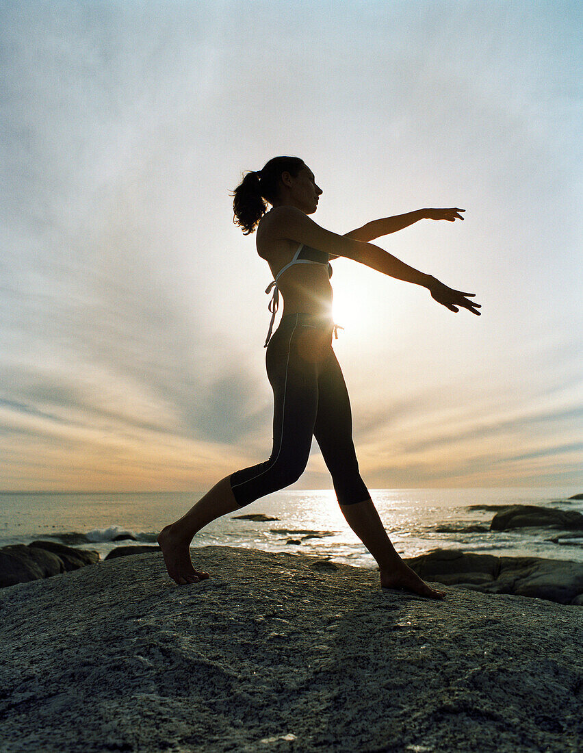 Frau übt Tai Chi am Strand, Silhouette