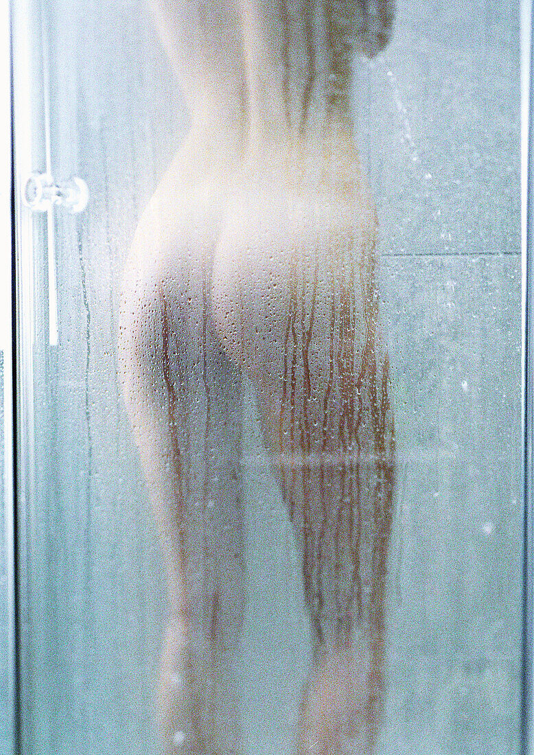 Frau unter der Dusche, Rückansicht.