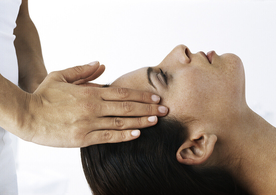 Woman receiving head message, side view, close-up