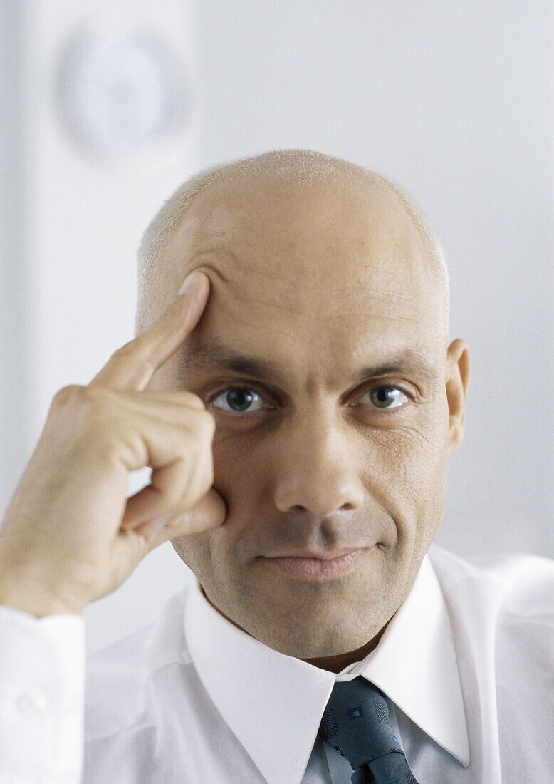 Businessman with fingers on face and forehead, portrait