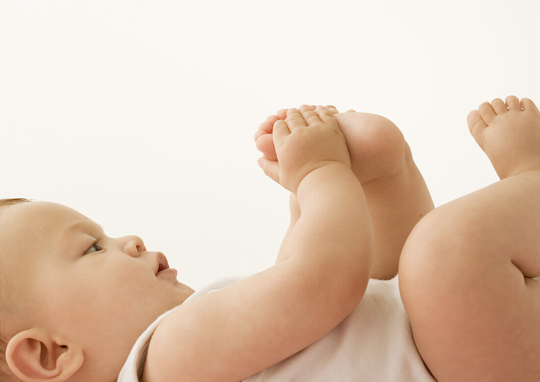 Baby lying down, holding foot