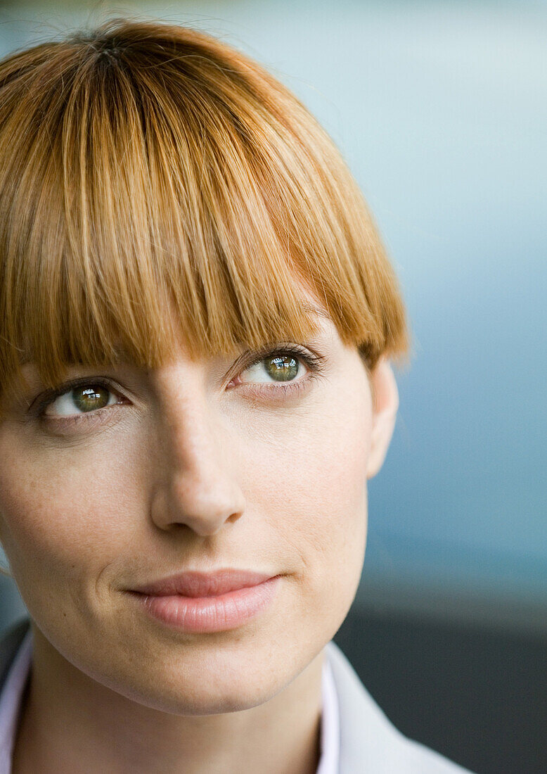 Woman with bangs looking up, portrait