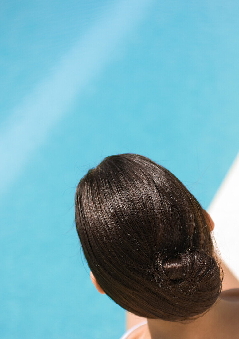 Hinterkopf einer Frau, Pool im Hintergrund