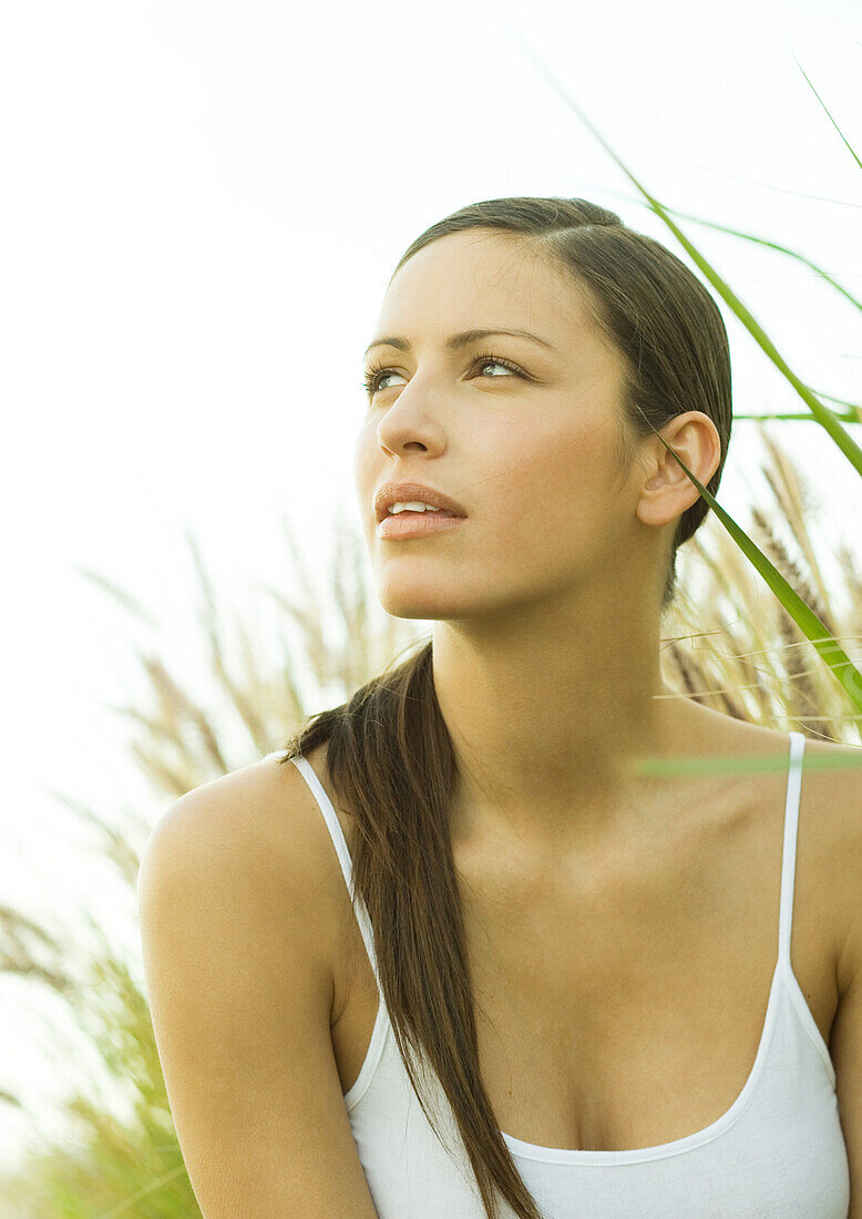 Woman in long grass, looking up