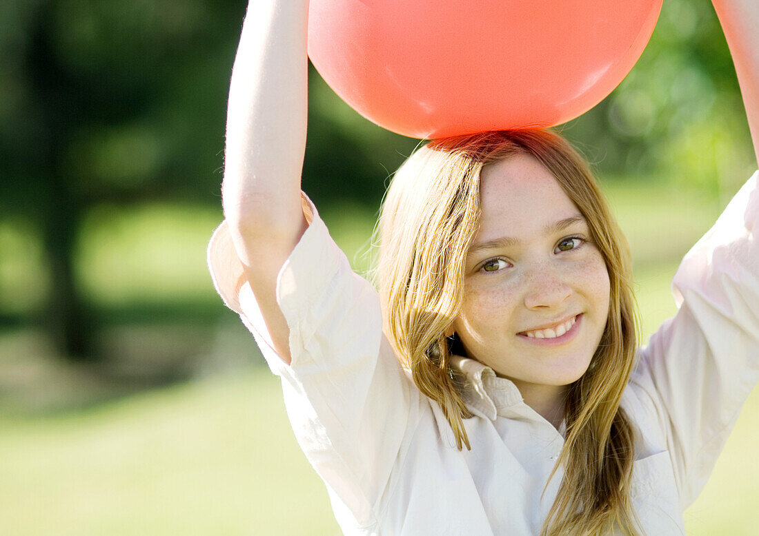 Girl holding ball on head