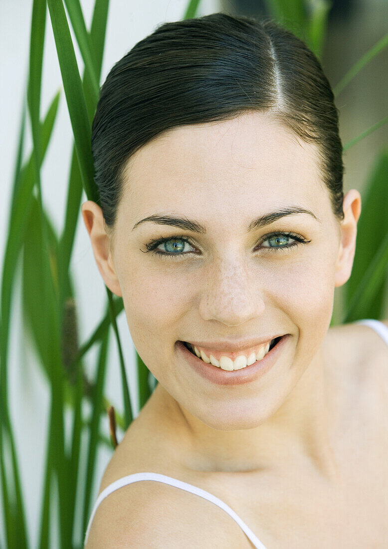 Young woman smiling, portrait, front view, close-up