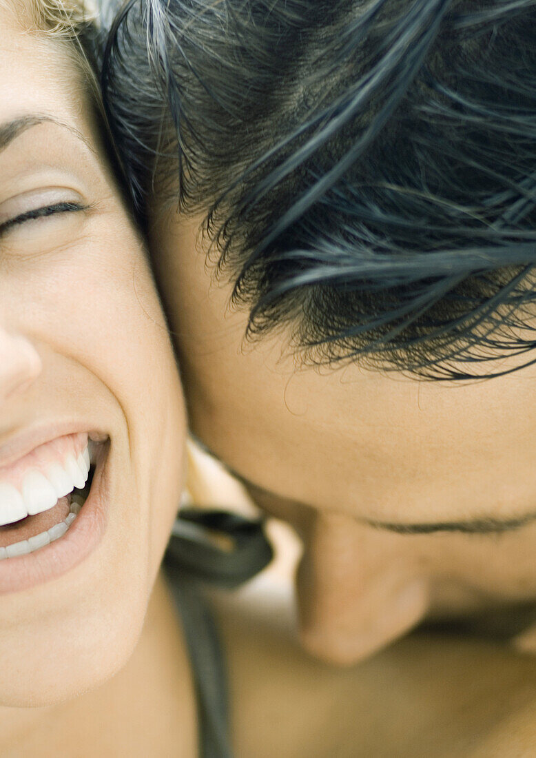 Man kissing woman's shoulder, woman laughing, close-up