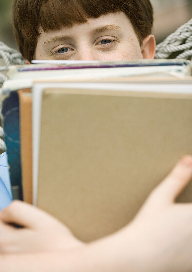 Boy holding stack of school books