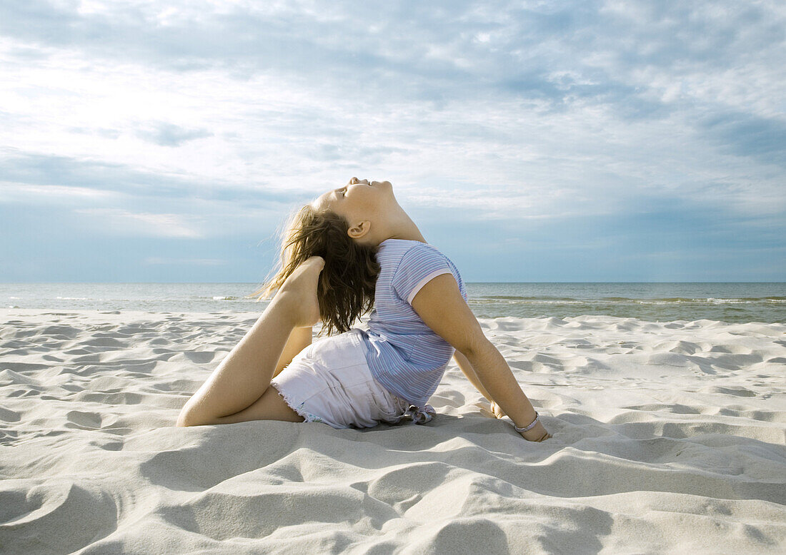 Girl doing yoga pose on beach