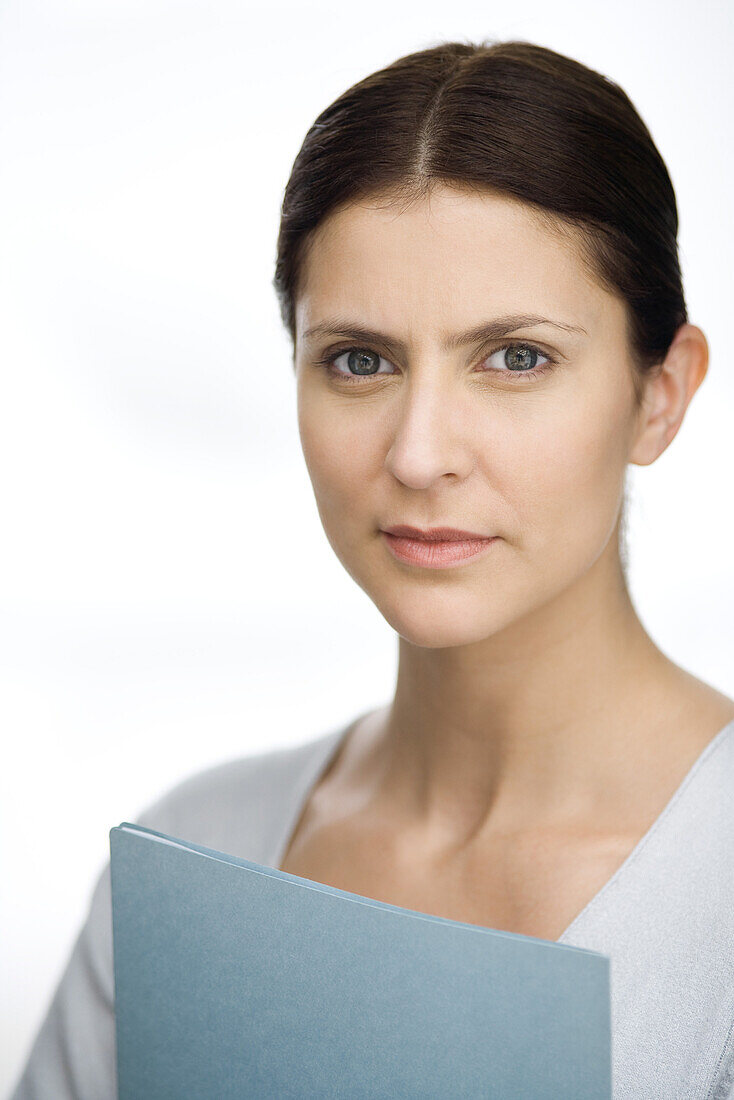 Woman holding file, looking at camera, portrait
