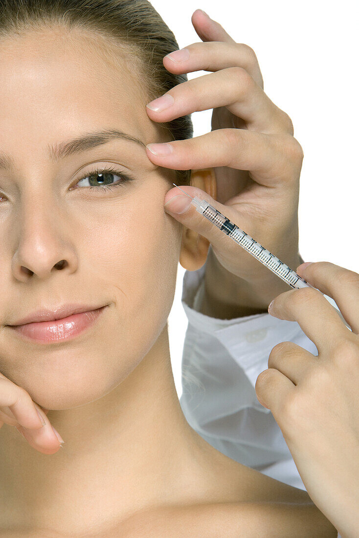 Young woman receiving Botox injection, cropped view