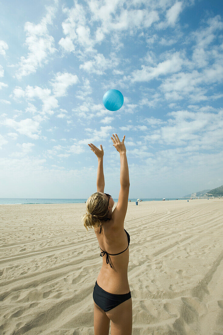 Teen girl playing beach volleyball