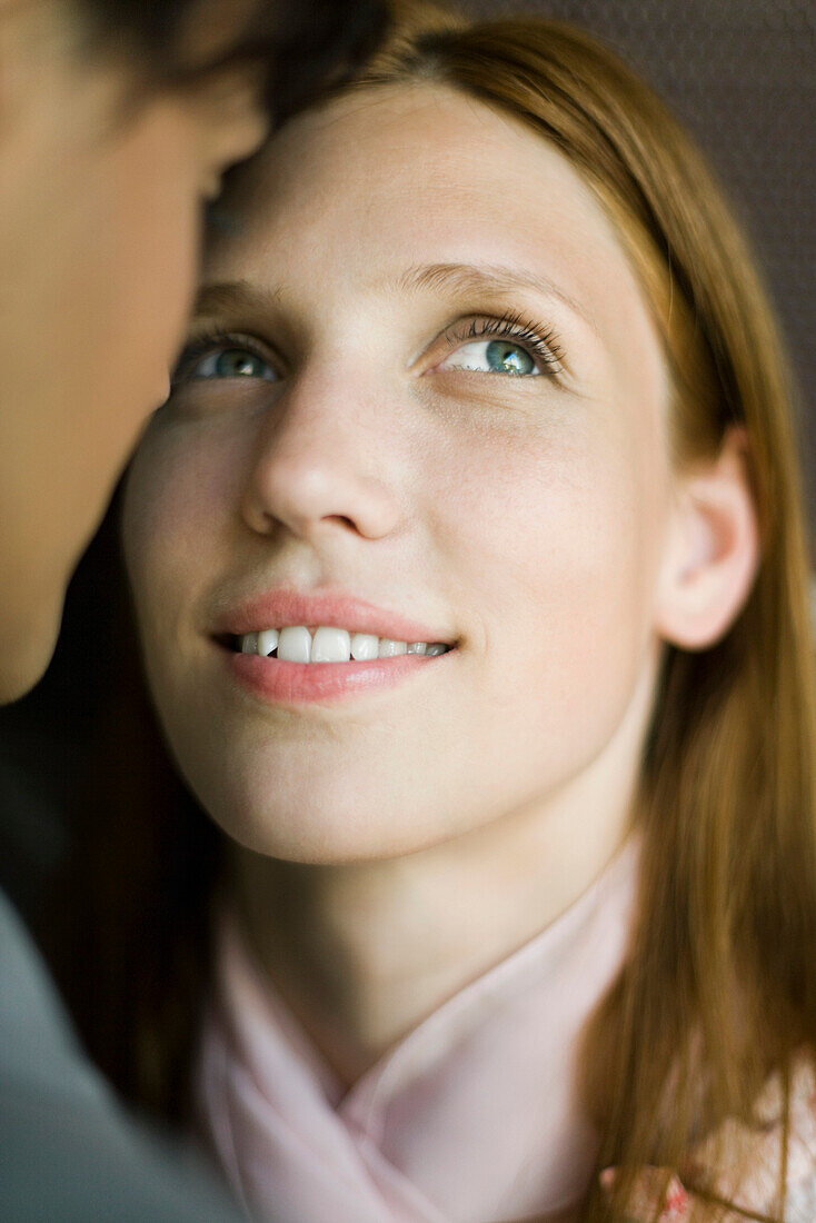 Young woman face to face with man, looking up hopefully, smiling