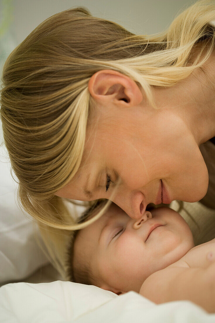 Young mother nuzzling sleeping baby