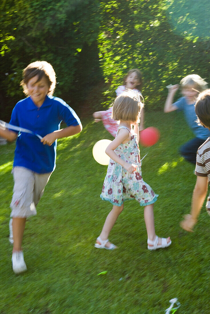 Children playing outdoors with balloons