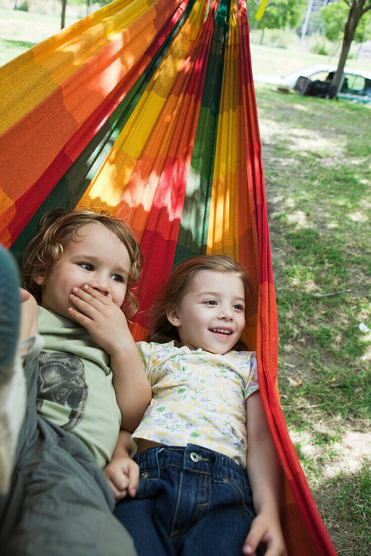 Young brother and sister lying in hammock together
