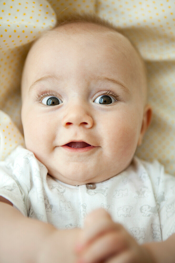 Infant looking at camera with wide eyes, portrait