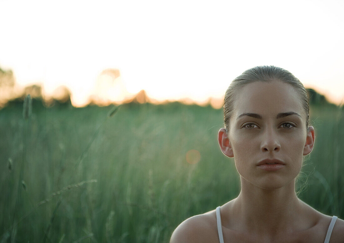 Woman, head and shoulders, green field in background, portrait