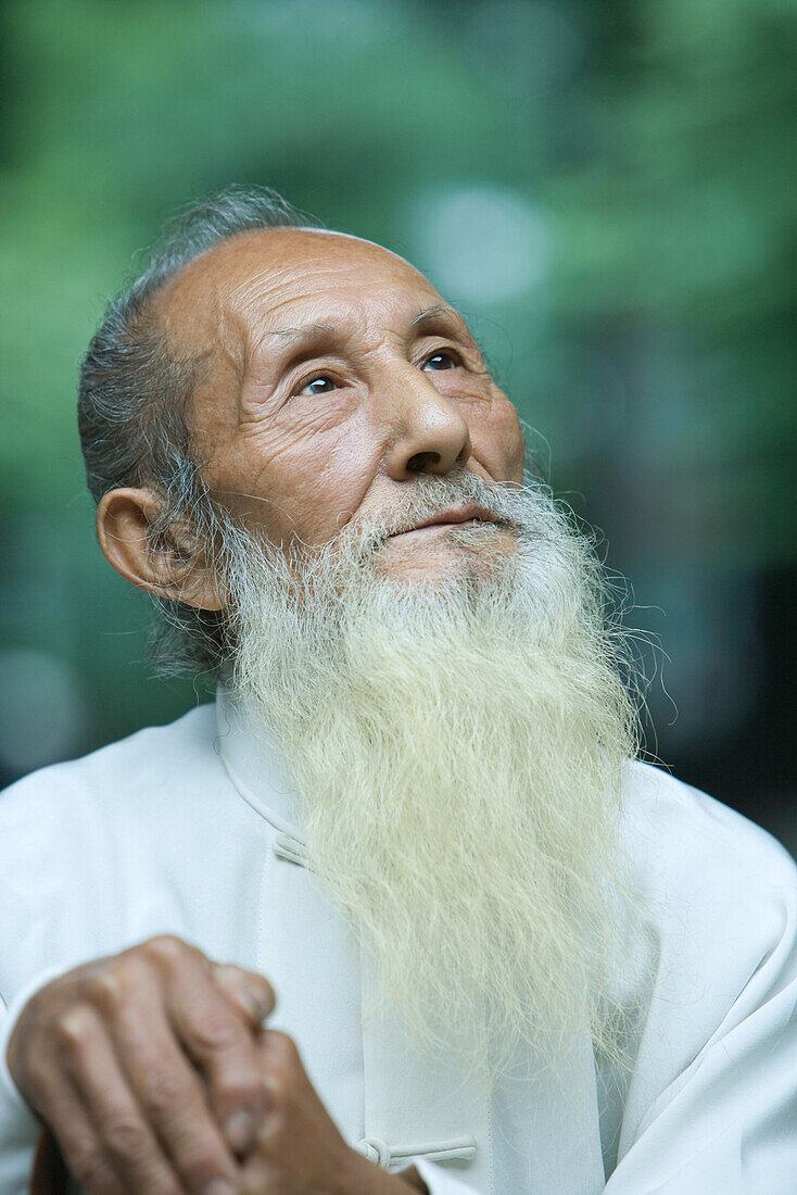 Elderly man in traditional Chinese clothing, looking up, portrait