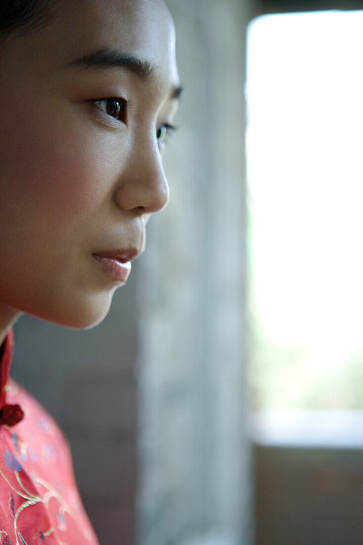 Young woman dressed in traditional Chinese clothing, profile, cropped view