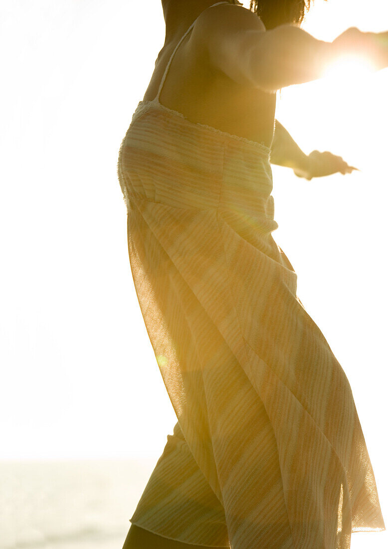 Woman wearing light dress in sun, cropped