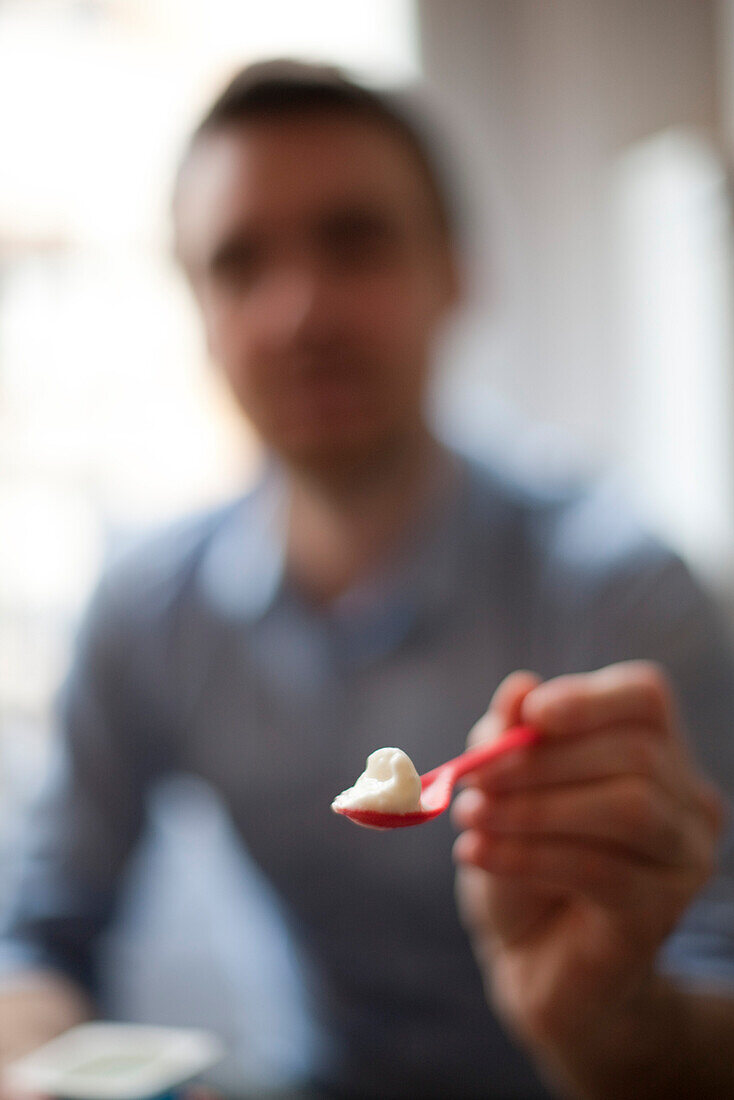 Person holding out spoonful of food, personal perspective