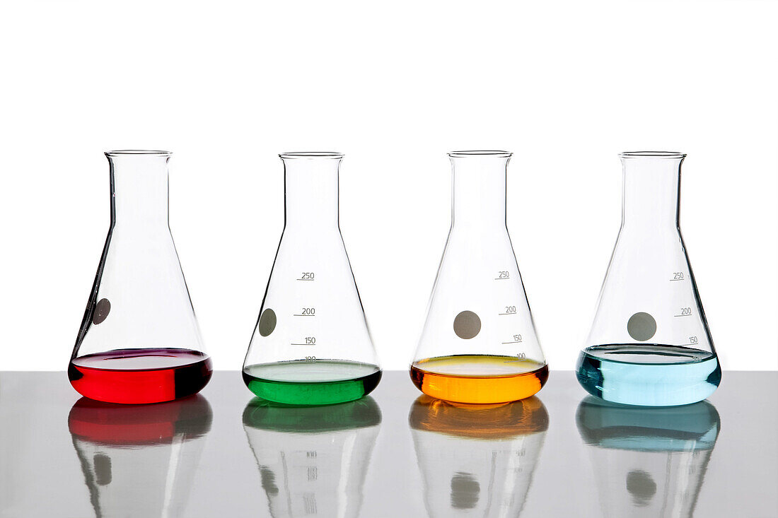 Four conical flasks holding different colored fluids