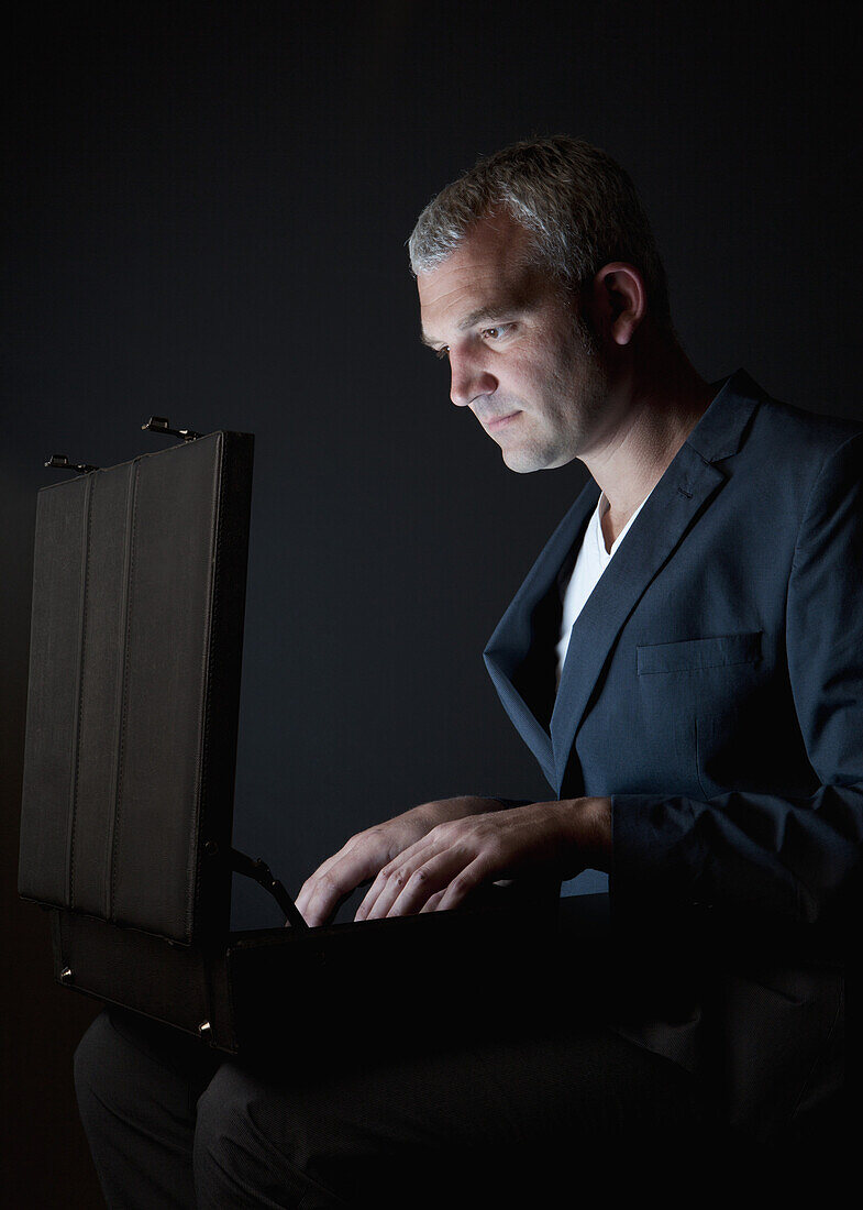 A businessman looking in a briefcase emitting light