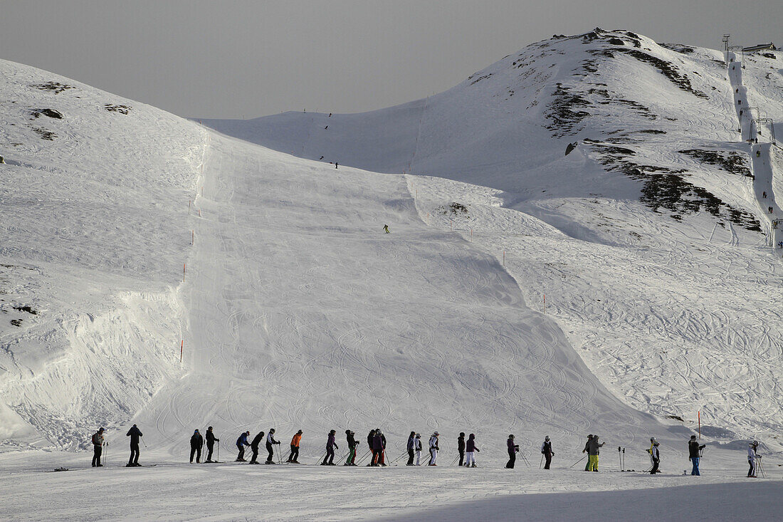 A line of skiers waiting for the ski lift, Oberalp Pass, Andermatt, Uri Canton, Switzerland